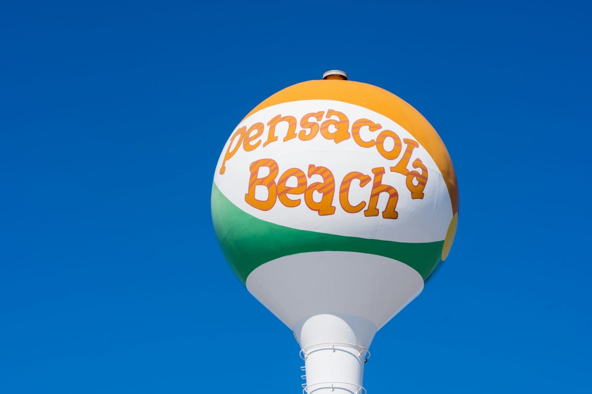 Pensacola Beach's iconic beach-ball water tower against a vivid blue sky.